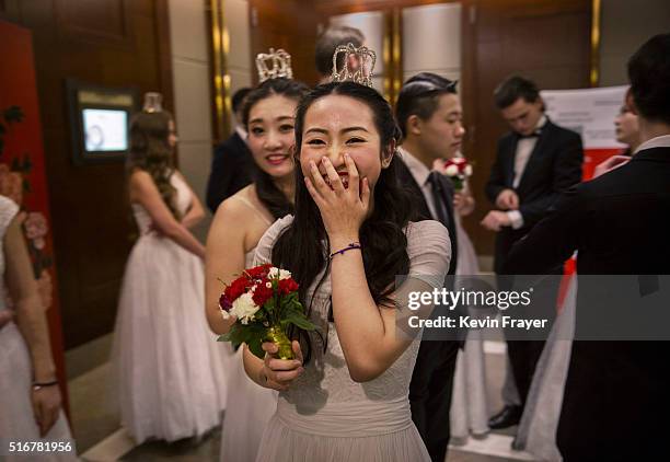 Debutante from a local academy laughs as she and others wait before taking part in the Vienna Ball at the Kempinski Hotel on March 19, 2016 in...