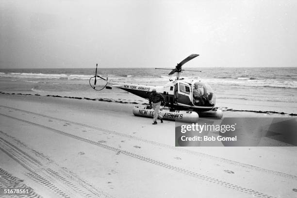 American public official and city planner Robert Moses disembarks from a helicopter on a Fire Island beach during a visit to a construction site,...