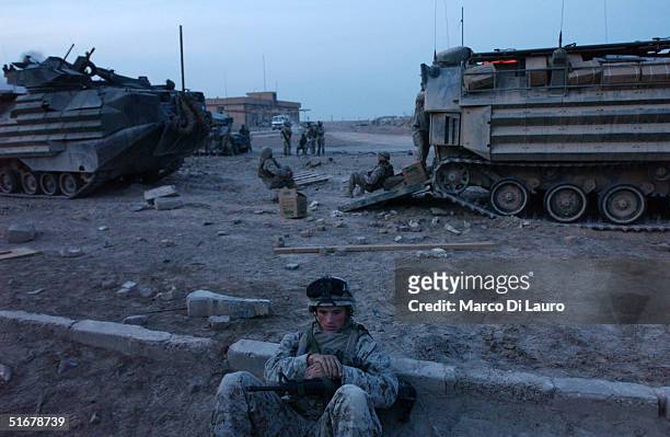 Marine from the 1st Expeditionary Force, 1st Battalion rests before preparing for a possible offensive November 5 near Fallujah, Iraq. U.S. Fighter...
