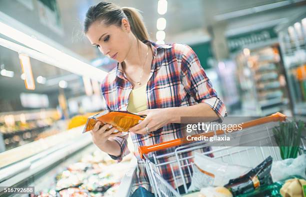 mulher comprar comida no supermercado. - comida congelada - fotografias e filmes do acervo