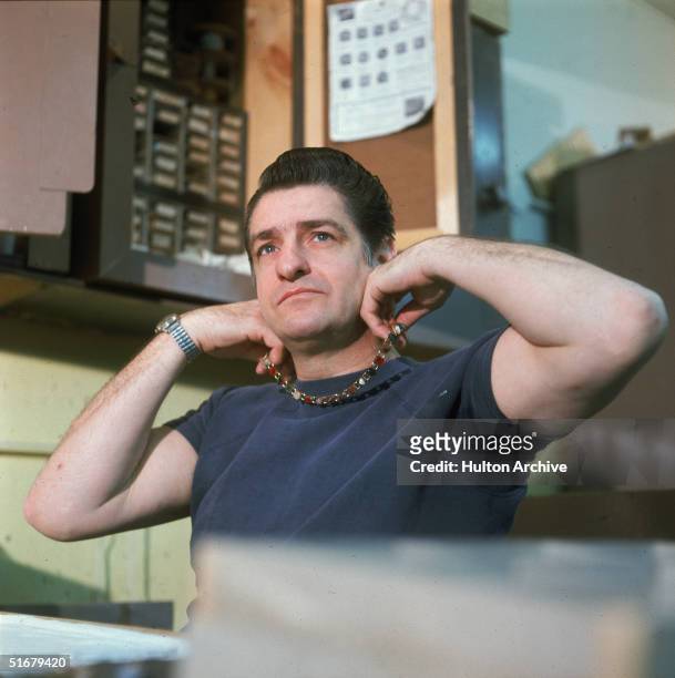 American Albert DeSalvo holds one of the necklaces he made while in prison up to his neck at Walpole State Prison, South Walpole, Massachusetts,...