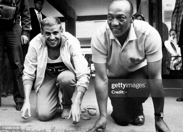 Athletics legend Jesse Owens poses and jokes with his fellow countryman Armin Hary, on September 2 at Rome after that the lastone won the 100m race...