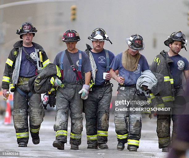 This 13 September 2001 photo shows five firemen leaving the rescue area near the World Trade Center after their shift in New York. Rescue efforts...