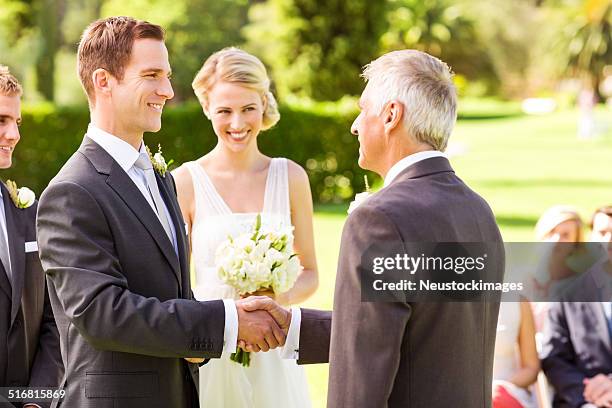 groom shaking hands with father in garden - bride father stock pictures, royalty-free photos & images