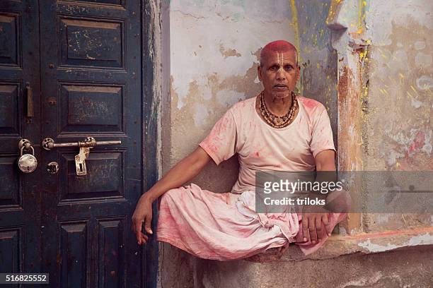 priest sitting outside of his house - uttar pradesh stockfoto's en -beelden
