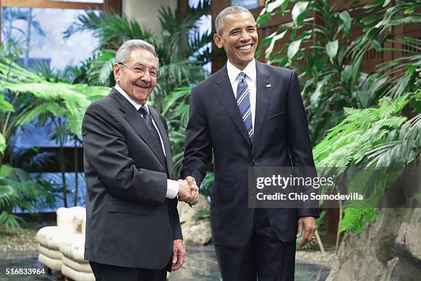 President Barack Obama and Cuban President Raul Castro pose for photographs after greeting one another at the Palace of the Revolution March 21, 2016...