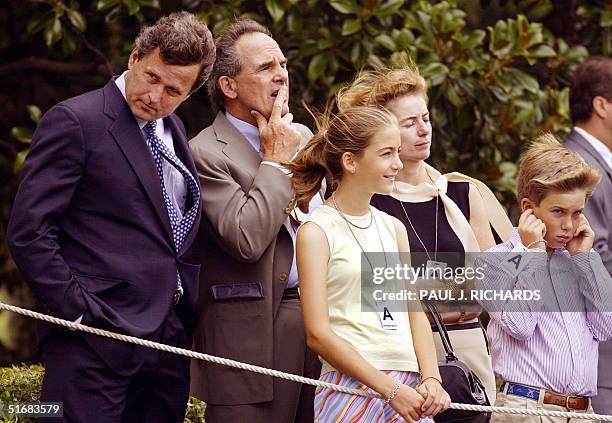 President George W. Bush's brother Marvin stands with unidentified friends as his brother takes off on Marine One 22 July 2002 from the South Lawn of...