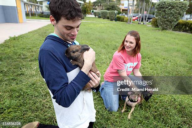 Josh Nackenson with his pet therapy rabbit, Peanut, and Crystal Jacques, with her pet therapy dog, Oliver, meet in a grassy area outside of the Arch...