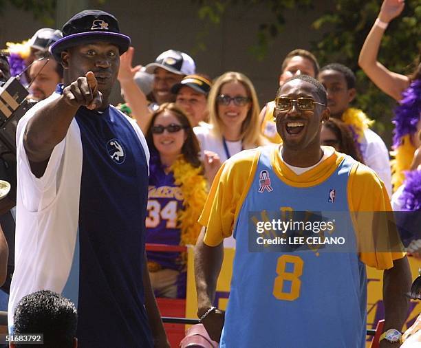 Los Angeles Lakers' Shaquille O'Neal and Kobe Bryant smile as they are honored on a stage at City Hall in Los Angeles, California, 14 June, 2002 for...