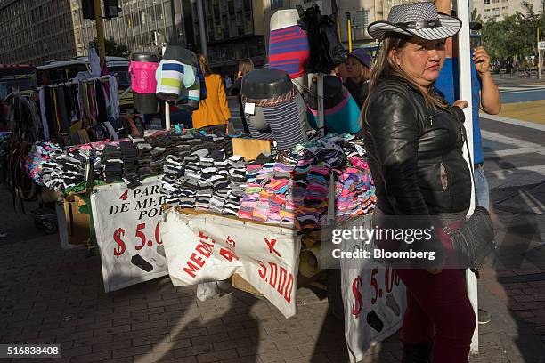 Woman selling socks and underwear waits for customers in Bogota, Colombia, on Tuesday, March 15, 2016. Colombia's central bank raised its benchmark...