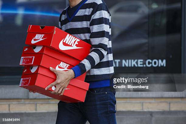 Customer carries boxes of Nike Inc. Shoes outside of the NikeTown Los Angeles retail store in Beverly Hills, California, U.S., on Sunday, March 20,...