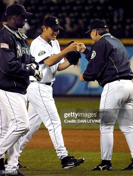 Seattle Mariners Kazuhiro Sasaki and coach John McLaren celebrate their team's 3-0 victory over the Kansas City Royals in Seattle, 03 July 2002....