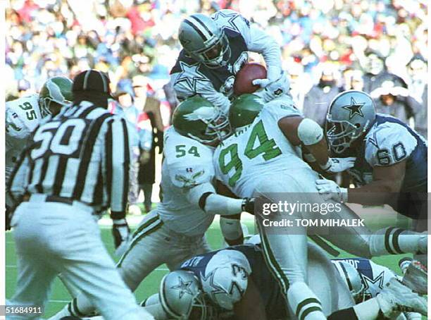 Running back Emmitt Smith of the Dallas Cowboys tries to go up and over to score but is stopped at the goal line by Philadelphia Eagles defenders...