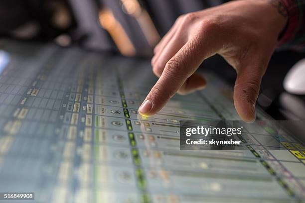 close-up of a man adjusting sound on digital sound mixer. - sound mixer stock pictures, royalty-free photos & images