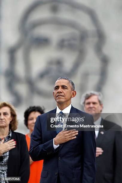 President Barack Obama listens to the playing of the U.S. National Anthem as they take part in a wreath laying ceremony at the Jose Marti memorial in...