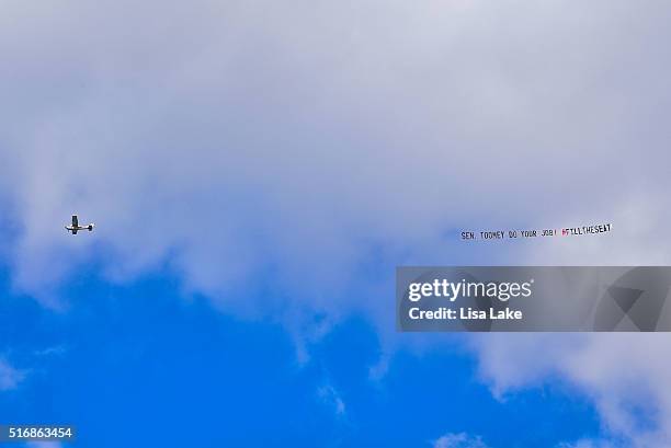 Airplane flys over downtown Harrisburg with a banner reading "SEN. TOOMEY DO YOUR JOB! #FILLTHESEAT" during National Day Of Action calling on Senate...