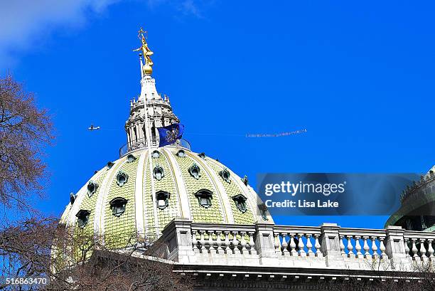 Airplane flys over PA State Capitol Building with a banner reading "SEN. TOOMEY DO YOUR JOB! #FILLTHESEAT" during National Day Of Action calling on...