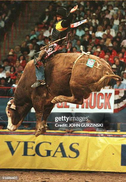 Todd Owens of Dewitt AZ is airborne on the back of the bull, Homer, 03 December during the third performance of the National Finals Rodeo at the...