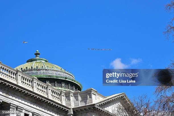 Airplane flys over PA State Capitol Building with a banner reading "SEN. TOOMEY DO YOUR JOB! #FILLTHESEAT" during National Day Of Action calling on...