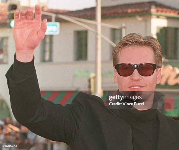 Actor Val Kilmer waves to fans as he arrives at the world premiere of the movie "Batman Forever" 09 June in Westwood, California. Kilmer replaces...