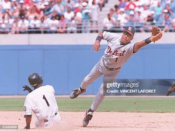 Chicago White Sox center fielder Lance Johnson steals second base as Detroit Tigers second baseman Lou Whitaker misses the high throw by Tigers...