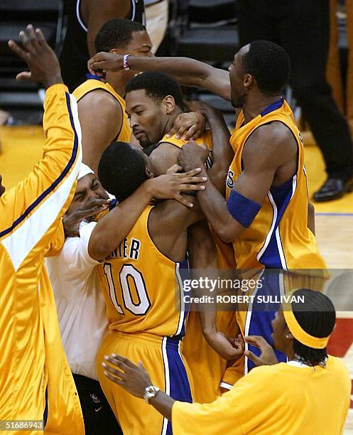 Robert Horry of the Los Angeles Lakers is mobbed by his teammates after he made the winning three-point basket to give the Lakers a 100-99 victory...
