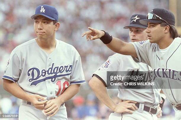 National League All-Star teammates Vinny Castilla of the Colorado Rockies and Craig Biggio of the Houston Astros point starting pitcher Hideo Nomo...