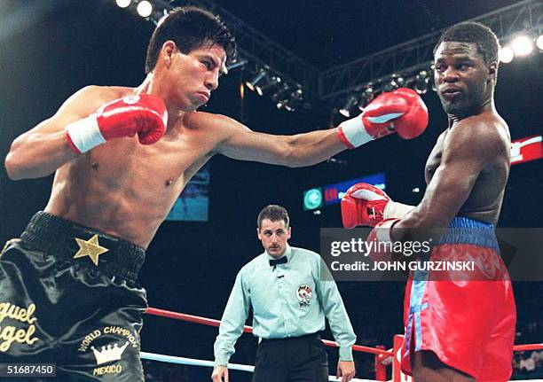 Referee Mitch Halpern looks on as World Boxing Council lightweight champion Miguel Angel Gonzalez of Mexico throws a punch at challenger Lamar Murphy...