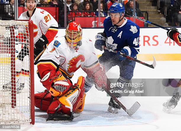 Michael Grabner of the Toronto Maple Leafs skates in front of Jonas Hiller of the Calgary Flames during game action on March 21, 2016 at Air Canada...
