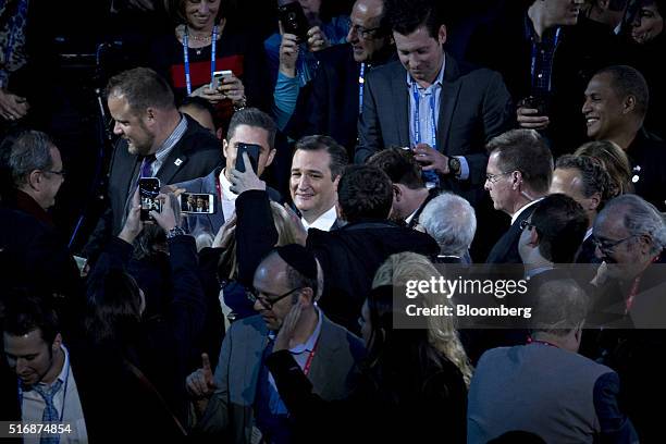 Senator Ted Cruz, a Republican from Texas and 2016 presidential candidate, center, takes photographs with attendees after speaking during the...