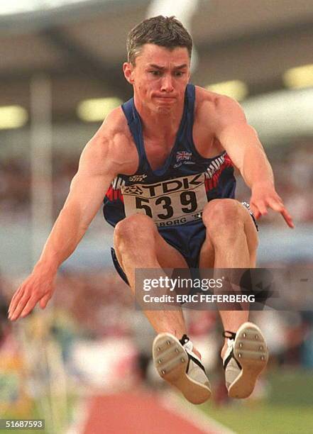 Jonathan Edwards of Great Britain stretches as he sets his new world record of 18.16 meters in the men's triple jump event at the World Championships...