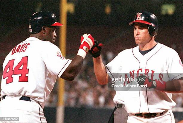 Tim Salmon of the California Angels is greeted by teammate Chili Davis after Salmon hit his second homerun of the game 04 August against the Texas...