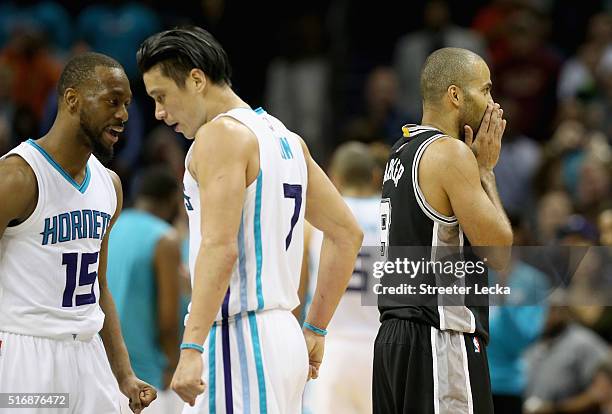 Teammates Kemba Walker and Jeremy Lin of the Charlotte Hornets celebrate as Tony Parker of the San Antonio Spurs reacts during their game at Time...