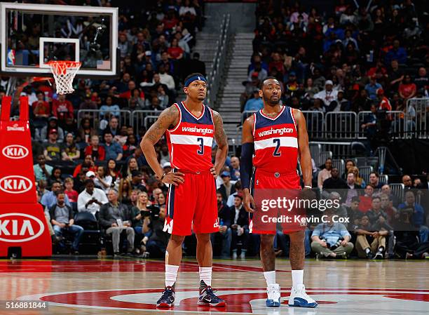 John Wall and Bradley Beal of the Washington Wizards look on during free throws against the Atlanta Hawks at Philips Arena on March 21, 2016 in...