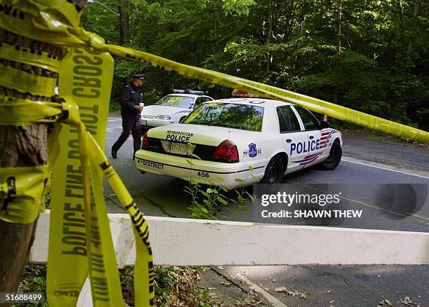 Washington Metropolitan Police officers secure the perimeter 23 May 2002 around the area where the remains of Chandra Levy were found at the Rock...