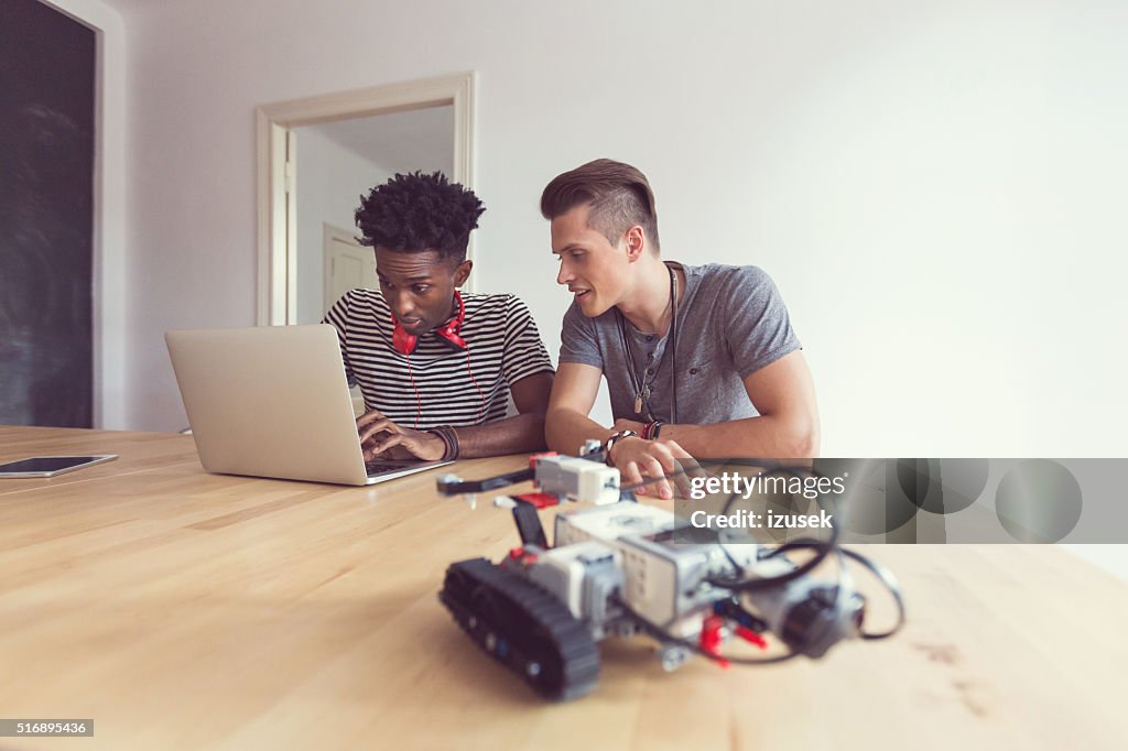 Two studens programming a robot