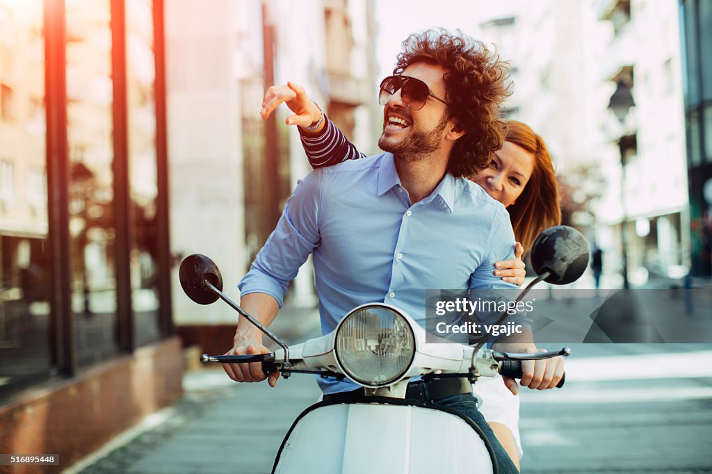 Fröhlich junges Paar Reiten auf einem Motorrad.