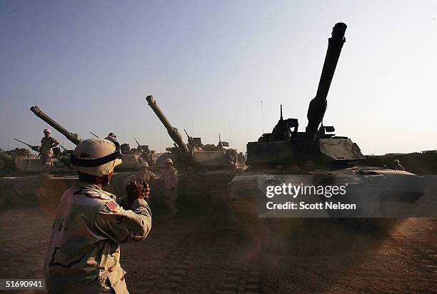 Army tanks are moved into a base, on November 4, 2004 on the outskirts of Falluja, Iraq. Several thousand U.S. Troops are poised for a massive strike...