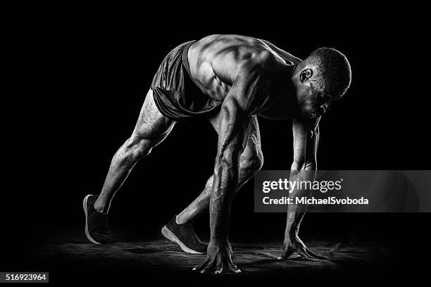 hombre muscular en posición inicial de una carrera - atletismo en pista masculino fotografías e imágenes de stock