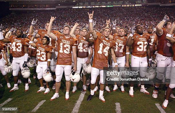 Members of the Texas Longhorns including punter Taylor Landin and place kicker Dusty Mangum join with the crowd in singing following a game against...