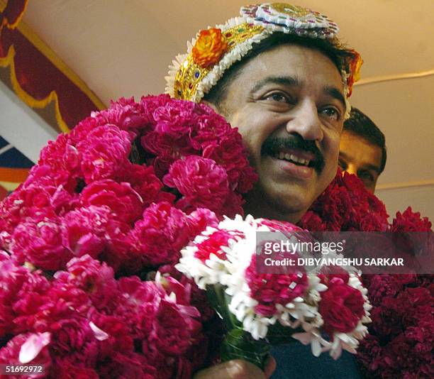 Indian film actor Kamal Hasan sports a garland of roses given by admirers at a function in Madras, 07 November 2004. Hasan was celebrating his 51st...