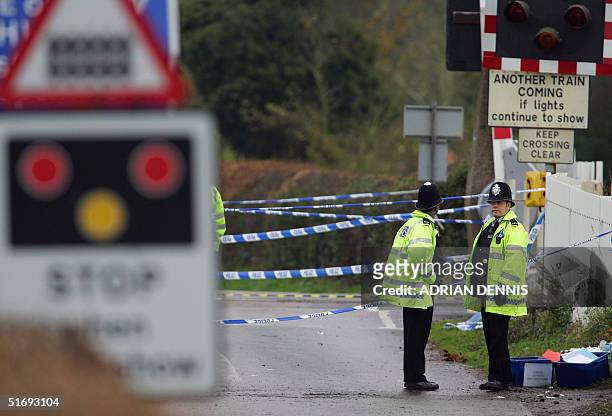 Police officers stand near a crossing the morning after a high-speed train hit a car on the crossing in the village of Ufton Nevet near Reading, west...
