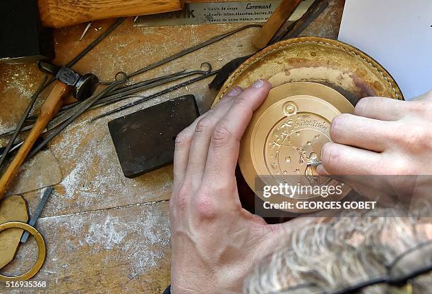 Man works on an etching mold displaying the Little Prince character on March 21, 2016 at the Monnaie de Paris in Pessac, western France . The Monnaie...