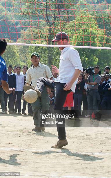 Prince Harry plays volleyball with local school children as he visits Gauda Secondary School, an earthquake-damaged school being reconstructed with...