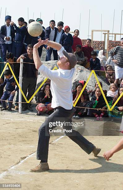 Prince Harry plays volleyball with local school children as he visits Gauda Secondary School, an earthquake-damaged school being reconstructed with...