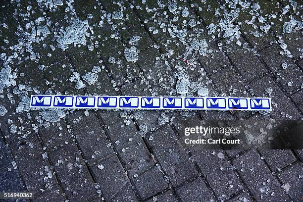 Broken glass and blood is seen beside signage outside an entrance to Maelbeek metro station following todays attack on March 22, 2016 in Brussels,...