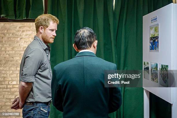 Prince Harry is shown photos of the Gurkha training process at the British Gurkha Camp on March 22, 2016 in Pokhara, Nepal. Prince Harry is on a five...