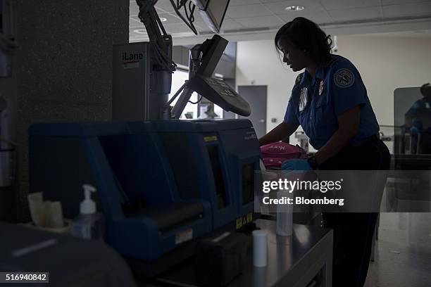 Transportation Security Administration officer hand checks a passenger's belongings in the TSA pre-check area at Dulles International Airport in...