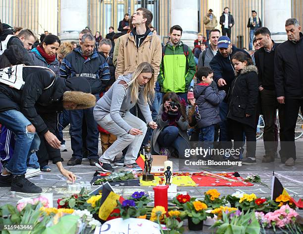 Wellwishers place flowers and floral tributes on Beursplein square as the Brussels stock exchange, operated by Euronext NV, stands beyond in...