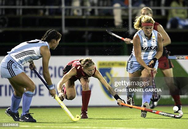 Argentine Vanina Oneto battles for the ball with German Marion Rodewald while teammate Soledad Garcia looks on during the field hockey match at the...